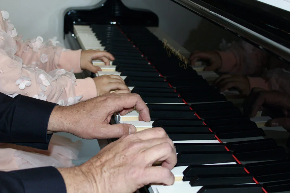Teacher and student hands at the keys