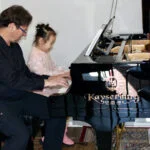 Hannah, age 5 at the piano with Dr. Silva