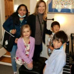 Group of students at the piano with Mireille Silva