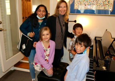 Group of students at the piano with Mireille Silva