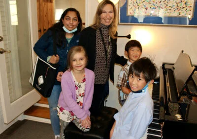 Group of students at the piano with Mireille Silva