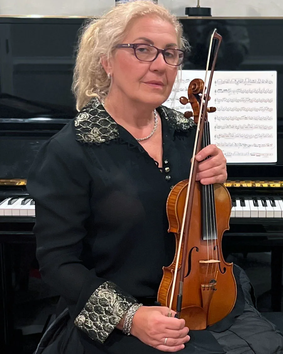 Photo, Mariya Tzvetkova sitting at piano holding violin